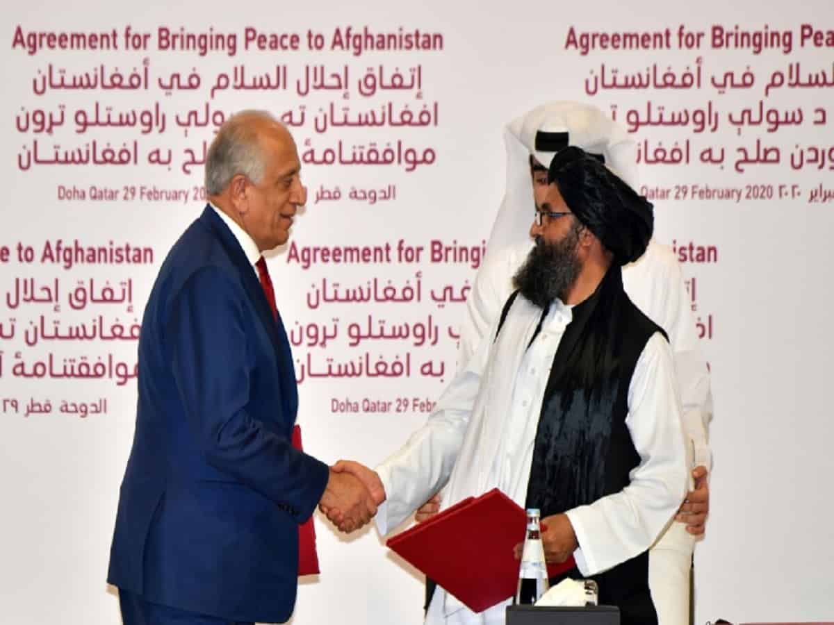US negotiator Zalmay Khalilzad shakes hands with Taliban co-founder Mullah Baradar after signing the landmark deal