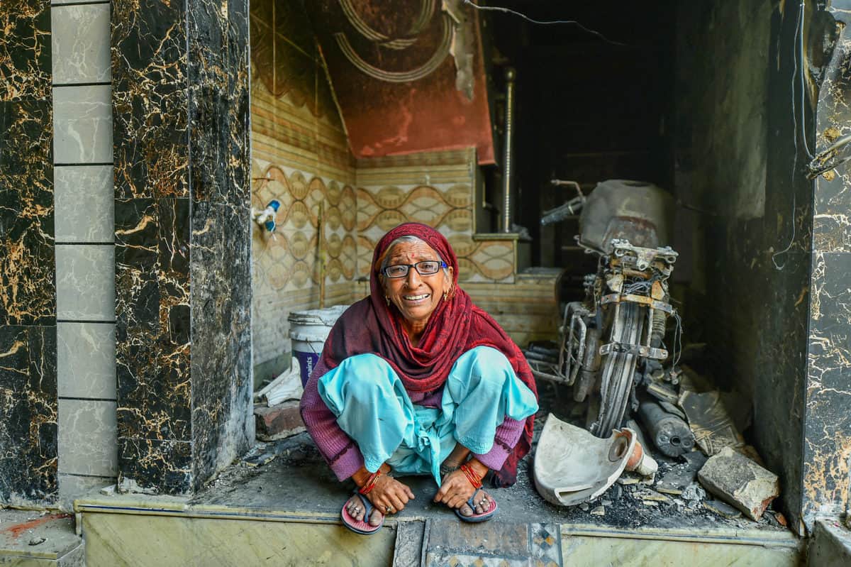 New Delhi: Munni Devi, a victim of recent communal violence, sits amid the charred remains of her house at Shiv Vihar in riot-affected Northeast Delhi, Monday, March 2, 2020. (PTI Photo)