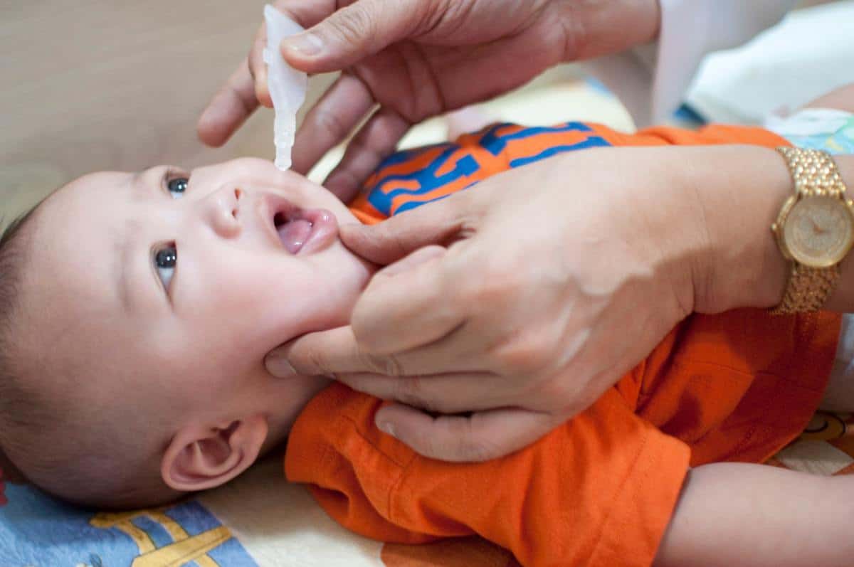 An oral vaccination of a baby boy in a clinic