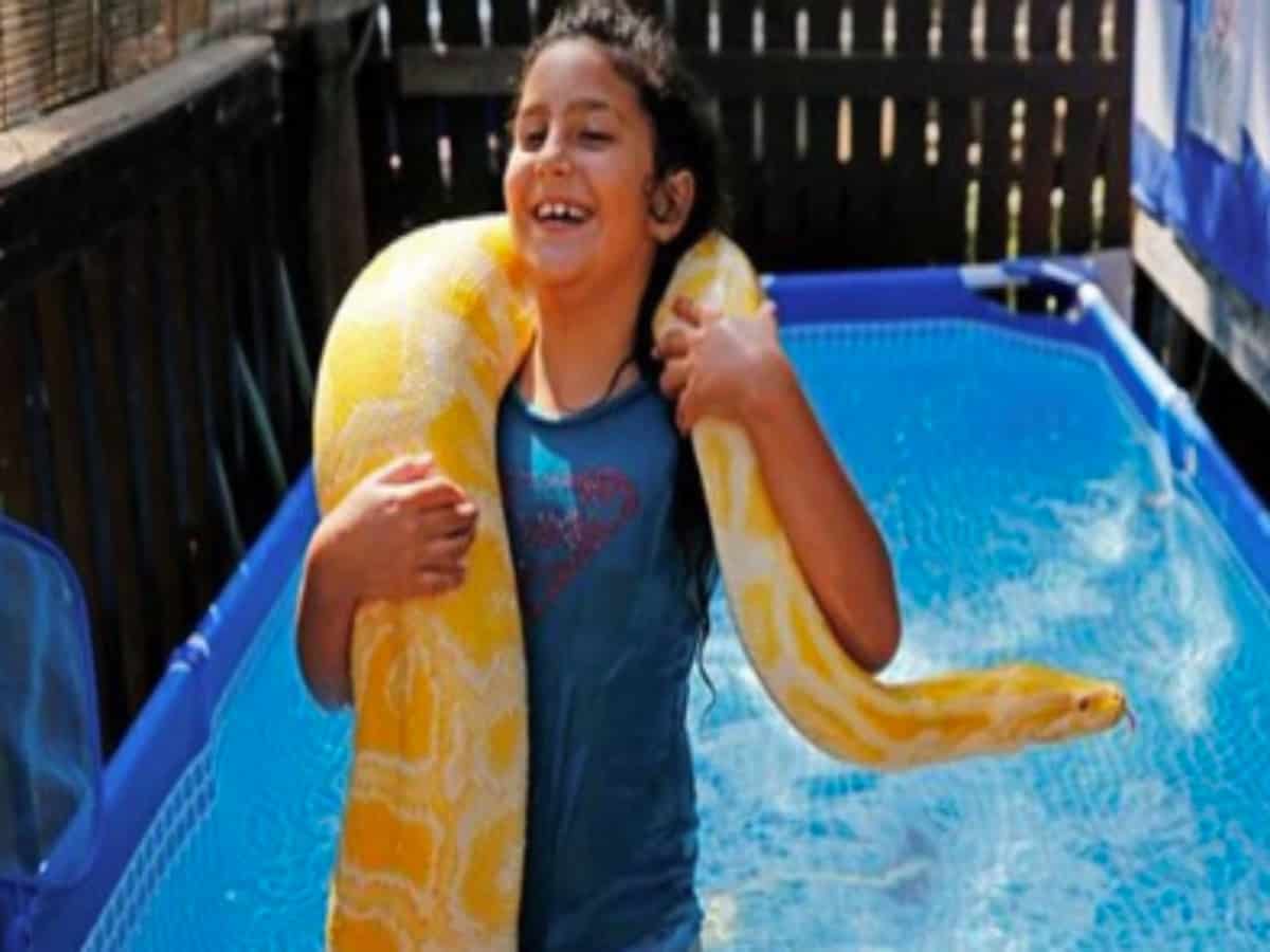 Israeli child takes 11-foot pet python 'Belle' for swimming