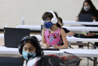 Scared by virus surge, more US schools suspend in-person classes