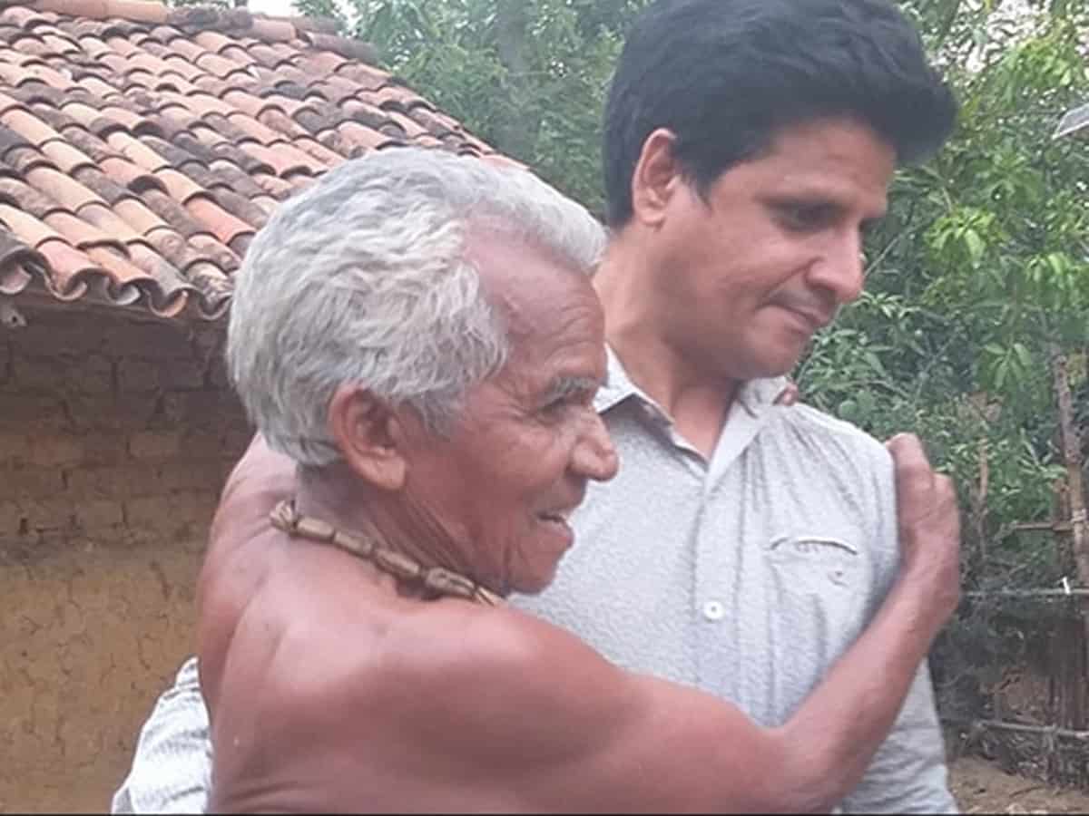 Shankar Ramchandani seen carrying a leprosy patient to his nearby hut. (File photo) Photo: twitter/ @amar4Odisha