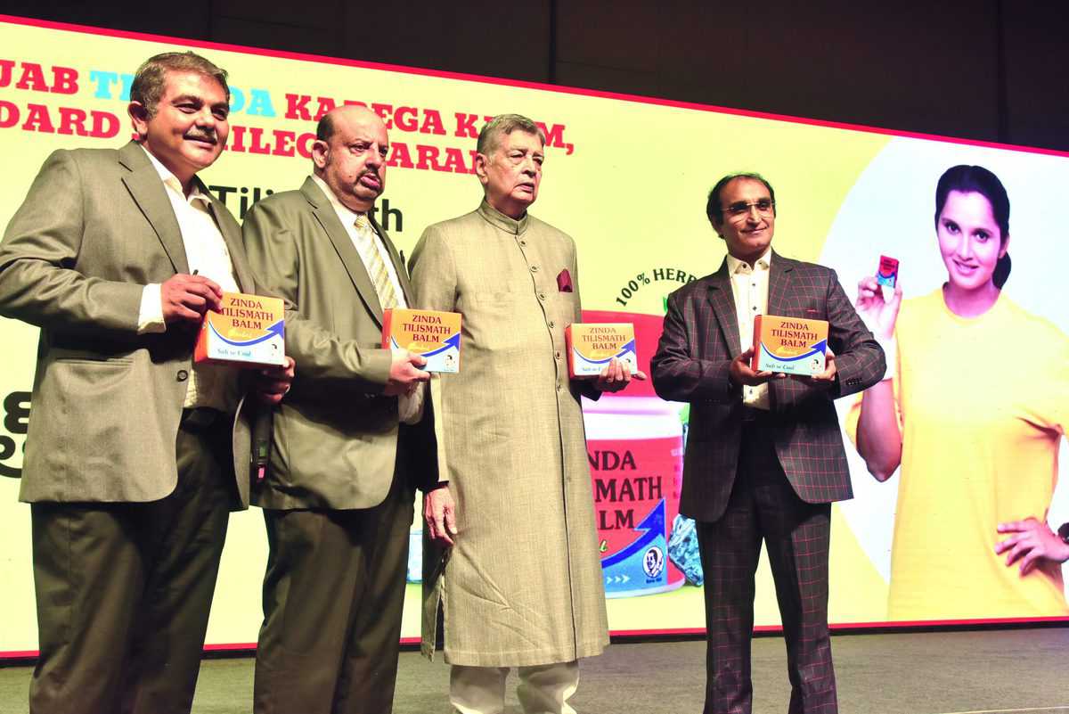 Managing partners of Karkhana Zinda Tilismath Masiuddin Farooqui, Sohail Farooqui, Imad Farooqui and Owais Farooqui showcase the Zinda Tilismath Balm after launching it during the company's centenary celebrations at Westin Hyderabad Mindspace in Hyderabad on Saturday. Brand Ambassador Sania Mirza is also seen in the backdrop.